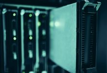 Fileiras de racks de servidores iluminadas em azul dentro de um data center moderno.