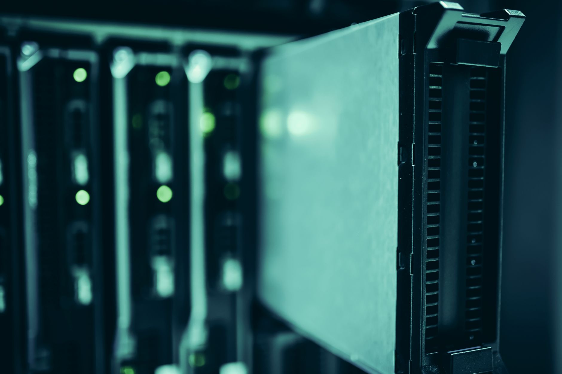Fileiras de racks de servidores iluminadas em azul dentro de um data center moderno.
