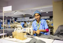 Trabalhadora usando uma máquina de costura em uma fábrica têxtil.